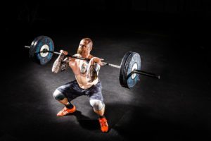 man doing squats with free weights workout routine