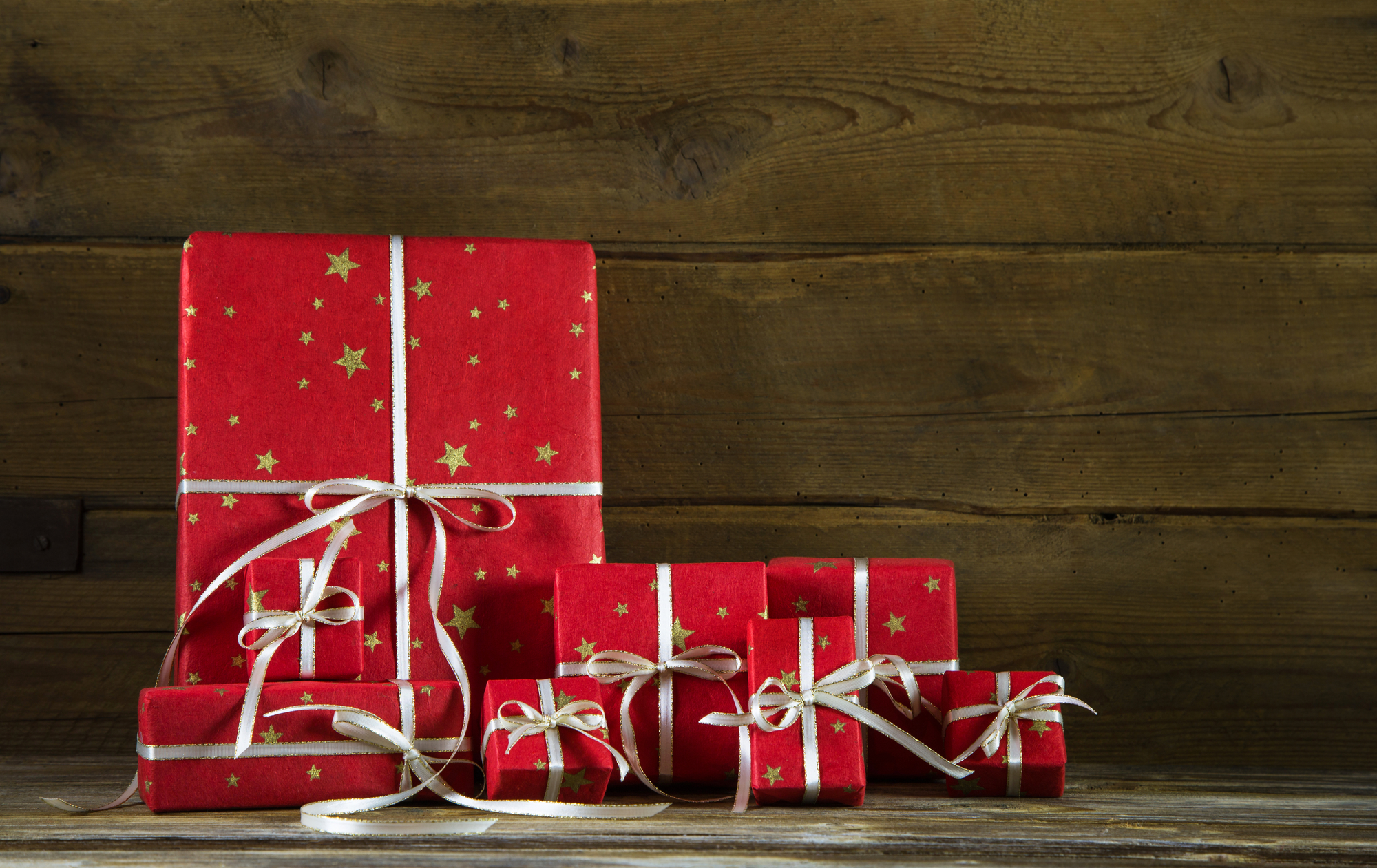 Red christmas presents on an old wooden brown background. - The Fit